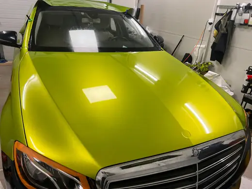 Dokončená limetková metalická fólia na kapote Mercedesu E-Class